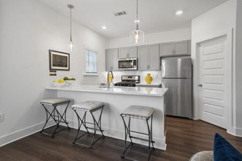 Modern kitchen with stainless steel appliances and large breakfast bar.